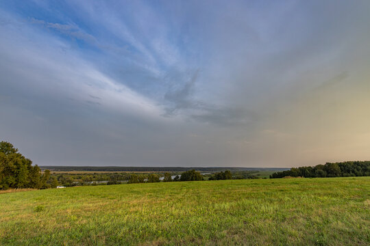 Large, open field with a cloudy sky in the background