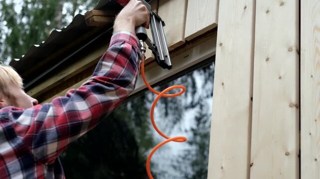 Skilled craftsman using pneumatic tool to install wooden panels