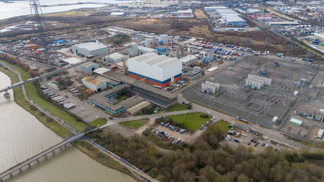 Aerial view of industrial buildings with red and blue accents stand in stark contrast to the surrounding gray landscape, Grays, England, United Kingdom.