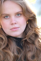 Portrait of a young woman in sunny autumn park	
