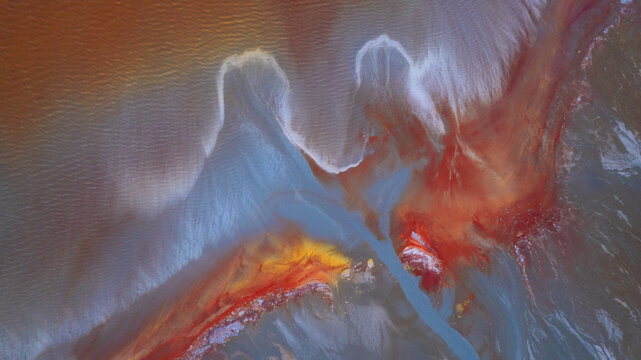 Aerial view of swirling, vibrant patterns of red and blue hues blend together, creating a surreal landscape, Ríotinto, Andalusia, Spain.