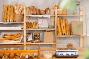 Inside bakery shop. Store offers fresh pastries, croissants, and bread for sale. Showcases are filled with bread products. .