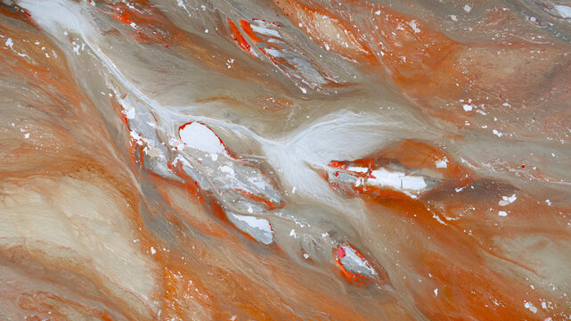 Aerial view of swirling, rust-colored waters intertwined with streaks of white and silver deposits create a mesmerizing, otherworldly landscape, R&iacute;otinto, Andalusia, Spain.