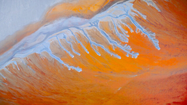 Aerial view of a surreal landscape where vibrant orange earth meets icy blue streams, creating a stunning contrast of warm and cool tones, R&iacute;otinto, Andalusia, Spain.