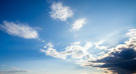Sunlit blue sky with scattered cumulus clouds.