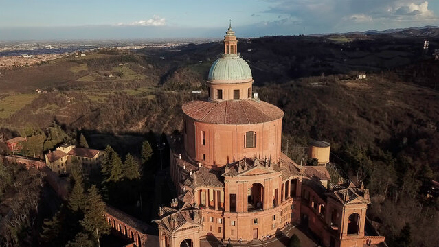 Aerial view of the Basilica di San Luca stands majestically, its terracotta hues contrasting with the verdant hills, a beacon of history and faith, Bologna, Emilia-Romagna, Italy.
