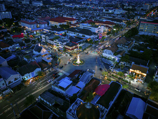 Aerial view of Tugu Jogja monument glows warmly amidst the city lights, a beacon at a bustling intersection, Yogyakarta, Daerah Istimewa Yogyakarta, Indonesia.