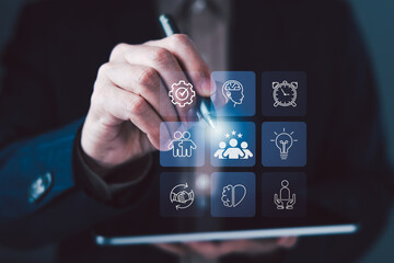 Hand pointing digital interface icons for teamwork, leadership, innovation, collaboration, and soft skills development concept on modern technology