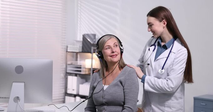Hearing test. Doctor adjusting patient's audiometric headphones in clinic