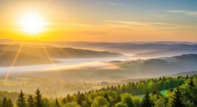 Stunning sunrise over a misty mountain valley landscape with sun flare illuminating the dense green forest in the foreground during a beautiful summer morning - Powered by Adobe