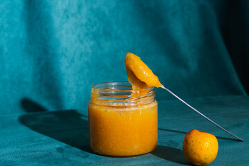 Quince jam in jar with spoon and fruit
