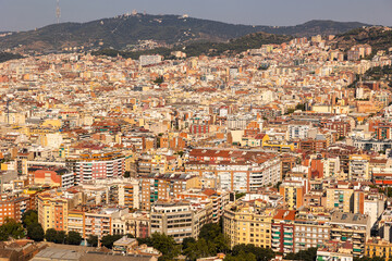 Roofs of houses create multicolored pattern of urban landscape. Elevated view of city of Barcelona, Spain. .