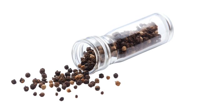 Black peppercorns spilling from a clear glass spice jar against a