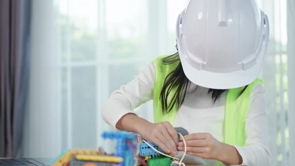 Young girl engineer working on robotics project in a STEM education class. child is focused on assembling and learning about a small robot or electronic project. engineering, innovation, technology. - Powered by Adobe