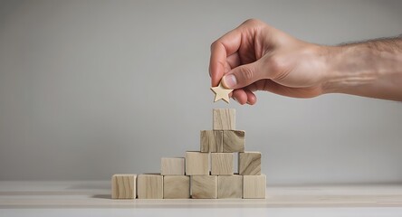 Hand placing wooden block on top of pyramid structure.