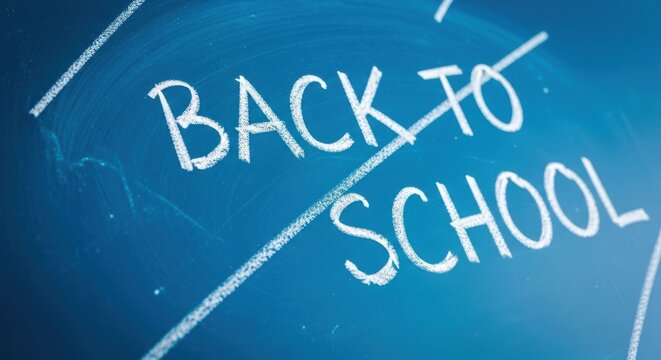 Closeup of the words back to school written in white chalk on a dark blue chalkboard, symbolizing the start of a new academic year or education concept