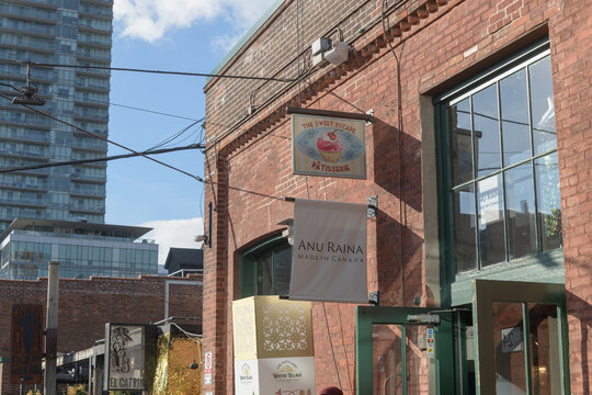 projecting signs outside The Sweet Escape and Anu Raina located at 24 Tank House Lane, Distillery District, Toronto