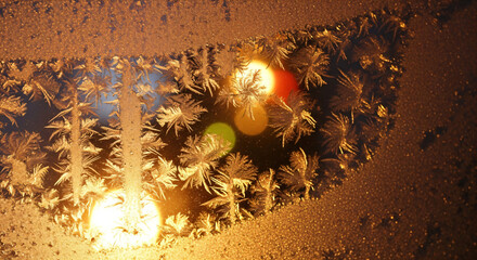 Golden ice crystals forming delicate patterns, capturing the magic of winter frost on glass with bright light and bokeh effects for a warm holiday feeling