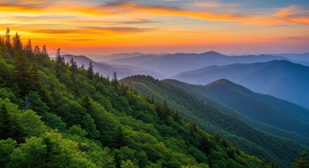 Stunning panoramic view of rolling, treecovered mountain ranges fading into the distance under a vibrant orange and yellow sunset sky, capturing the serene beauty of nature at dusk