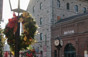 Fototapeta premium wreath and lamp post and view of historic buildings at The Distillery Winter Village 2025 (John Fluevog Shoes Toronto Distillery) 