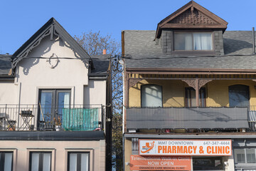 Fototapeta premium exterior building facade and sign of Enhanced Care Clinic - MMT Downtown Pharmacy, a walk-in clinic, located at 218 Gerrard St E, Toronto
