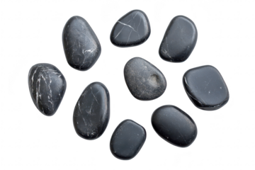 A collection of smooth. polished black stones arranged artistically on a white background. their unique shapes and textures. ideal for use in design or wellness contexts