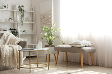 Interior of light living room with cozy grey sofa and coffee table
