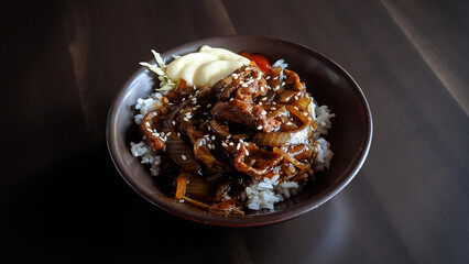 cooked homemade tasty spicy beef yakiniku seasoned sliced beef meat with condiment and warm rice served in black bowl