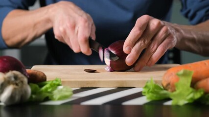 Closeup of man slicing red onion on a wooden kitchen board, preparation of fresh vegetables for home cooking and healthy lifestyle concept - Powered by Adobe