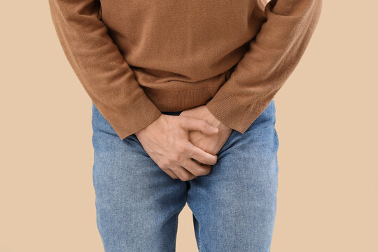 Young man with prostate problem on beige background, closeup. Cancer awareness concept - Powered by Adobe