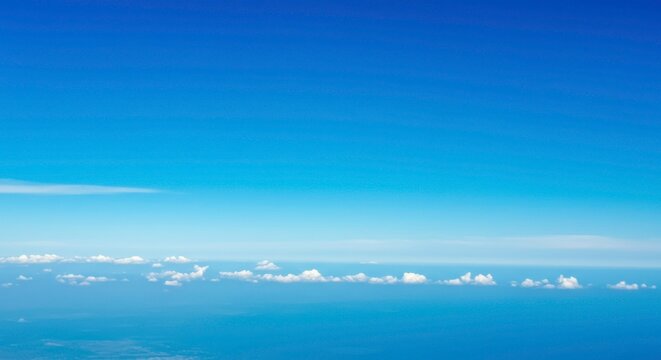 Stunning aerial view capturing the vast expanse of a clear blue sky and distant clouds showcasing - Powered by Adobe