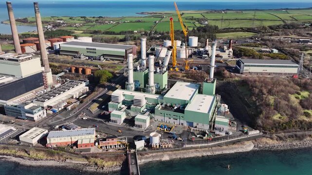 Aerial Video of workmen and Cranes taking down the fallen chimney after Storm Darragh at Ballylumford Power Station Larne Northern Ireland 04-03-25
