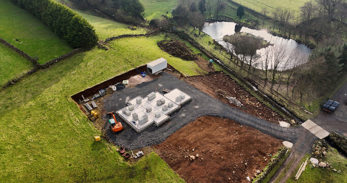 Aerial View of a digger at a building site constructing new homes in UK