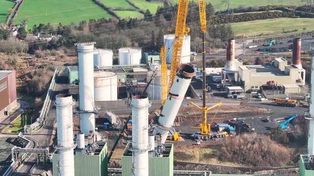 Aerial Video of workmen and Cranes taking down the fallen chimney after Storm Darragh at Ballylumford Power Station Larne Northern Ireland 04-03-25