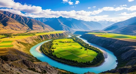 Stunning aerial view of a dramatic river meander carving through a vast valley surrounded by rugged mountains under a bright blue sky with scattered clouds, showcasing vibrant autumn colors