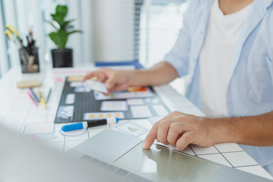 A male designer focused on UX UI tasks, creating app prototypes with wireframes, sketches, and color palettes. He works with creative ideas to optimize user interface and usability.