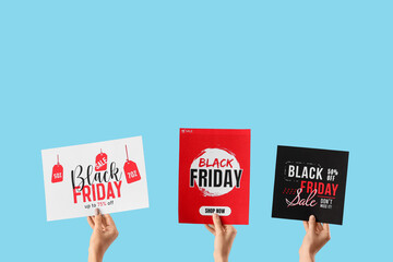 Female hands holding cards with text BLACK FRIDAY SALE on blue background