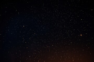 Dark Night Sky Filled With Countless Bright Stars and Illuminated Horizon in Deep Space