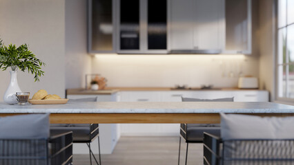 Coffee cup and bread on marble dining table and chairs across kitchen cooking counter under cupboard