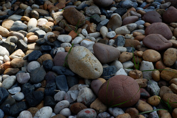 Serene abstract background of smooth natural pebble stone texture. sunlight casts strong shadow over colorful rock in peaceful garden setting creating calm mood
