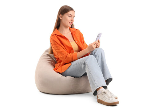 Beautiful young woman with modern mobile phone sitting on beanbag chair against white background