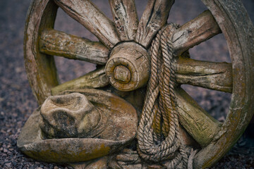 Close up of old wooden wheel, weathered rope and cowboy hat, Timboon, Victoria, Australia