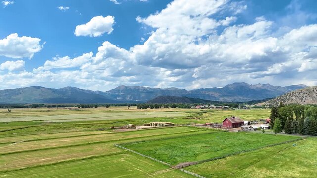 Aerial Green Fields Red Barn and Mountain Landscape Jackson Wyoming Flyover