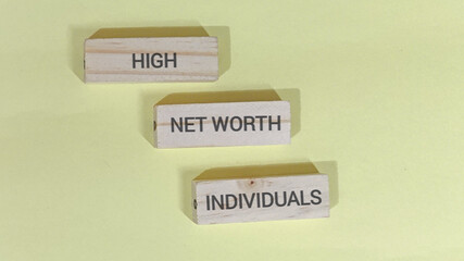 Conceptual representation of affluent clientele and financial status using wooden blocks arranged as steps on a plain background