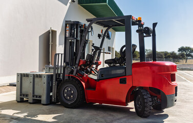 counterbalanced forklift outside industrial warehouse setting, lifting and transporting heavy cargo, material handling needs in various industries