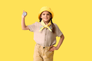Little girl scout with compass on yellow background. World Scout Day © Pixel-Shot