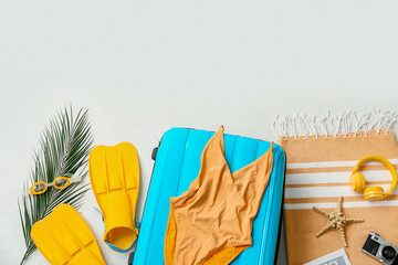 Suitcase, headphones, flippers and beach accessories isolated on white background, closeup © Pixel-Shot