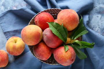 Bowl of fresh peaches on blue background, top view