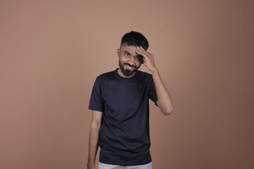 Young man, Person Touching Forehead in Thoughtful Pose – Brown Background Scene, Gesture, Emotion, Lifestyle, Expression, Background