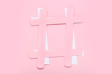 Hashtag made of paper on pink background